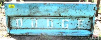 A blue dodge truck is parked in the grass.