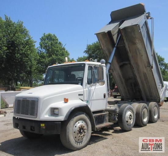 A dump truck is parked in front of a cbm auction sign