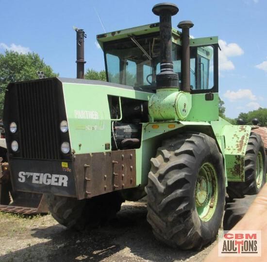 A green steiger tractor is parked on the side of the road
