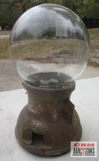A gumball machine with a clear glass ball inside of it