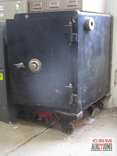 A large black safe is sitting on the floor in a room.