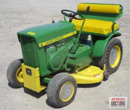 A green and yellow john deere lawn mower is sitting in the dirt