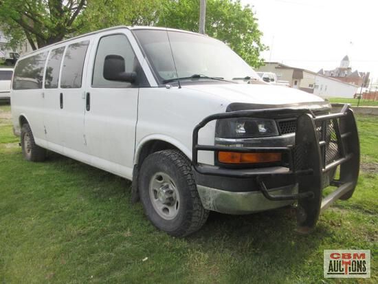 A white van is parked in a grassy field.