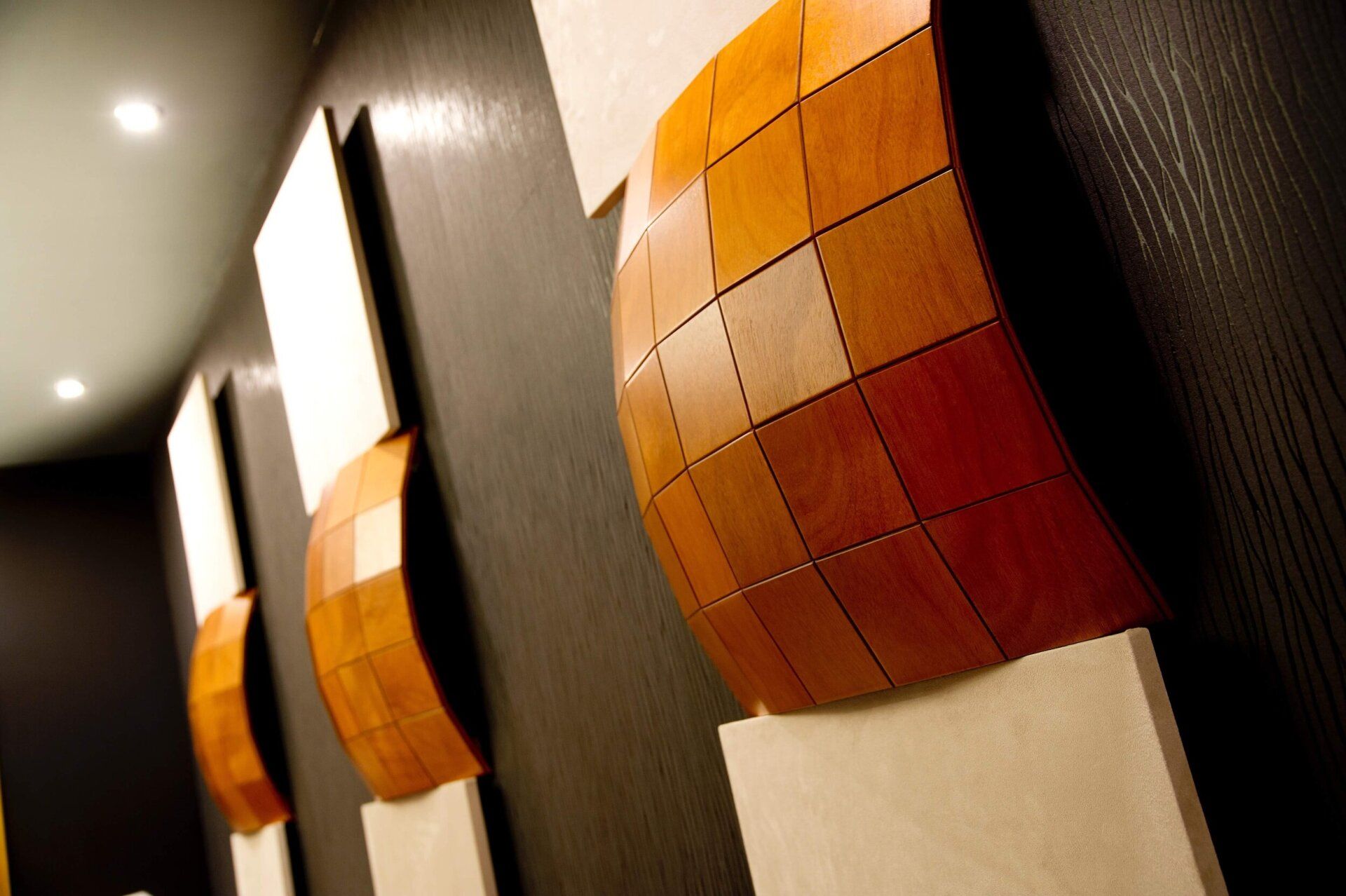 Abstract orange and cream wall art panels in a modern hallway