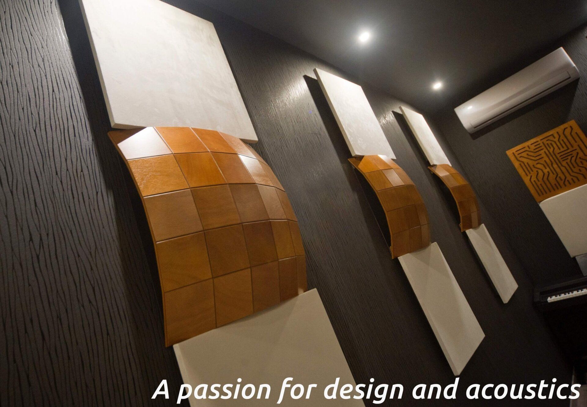 Acoustic wall panels in a modern room with warm wood accents and black ceiling lighting.