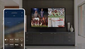 Living room with wall-mounted TV showing sports, and a smartphone displaying a TV remote app
