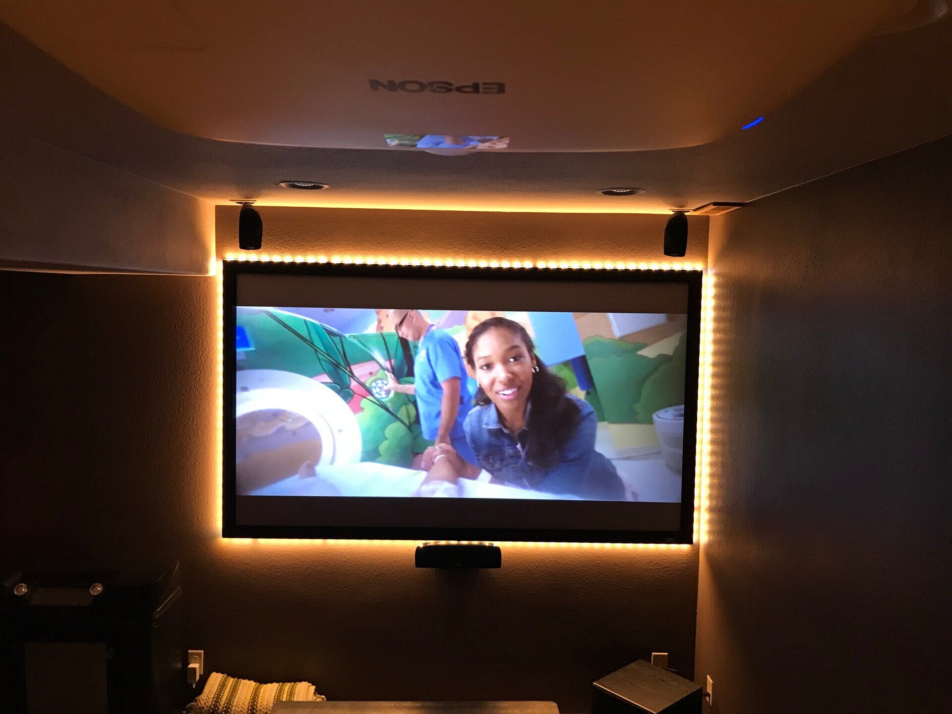 TV showing a smiling woman in a dim room with warm LED backlighting
