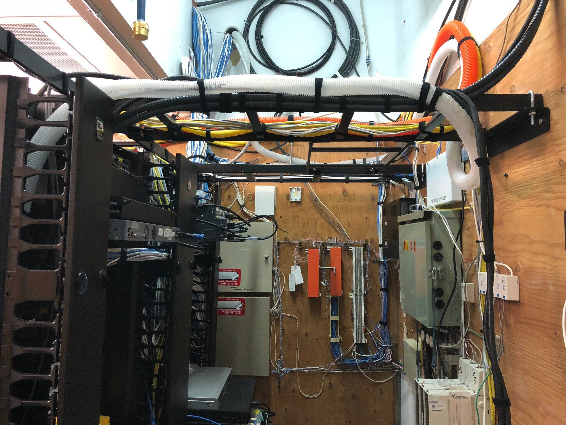 Electrical equipment room with wiring, panels, and cable bundles on the walls and ceiling.