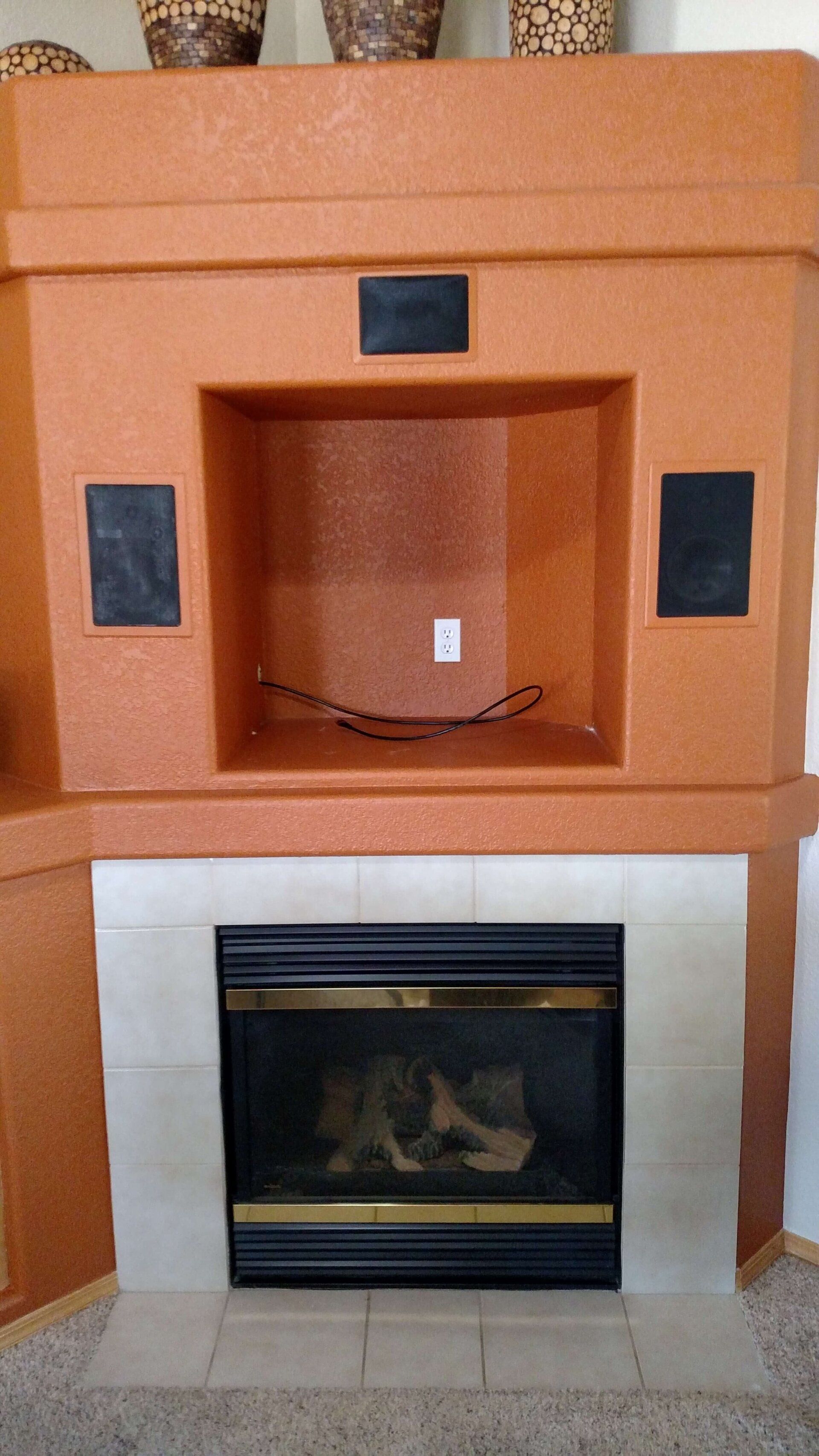 Orange fireplace wall with a white fireplace insert and built-in black accent panels above.