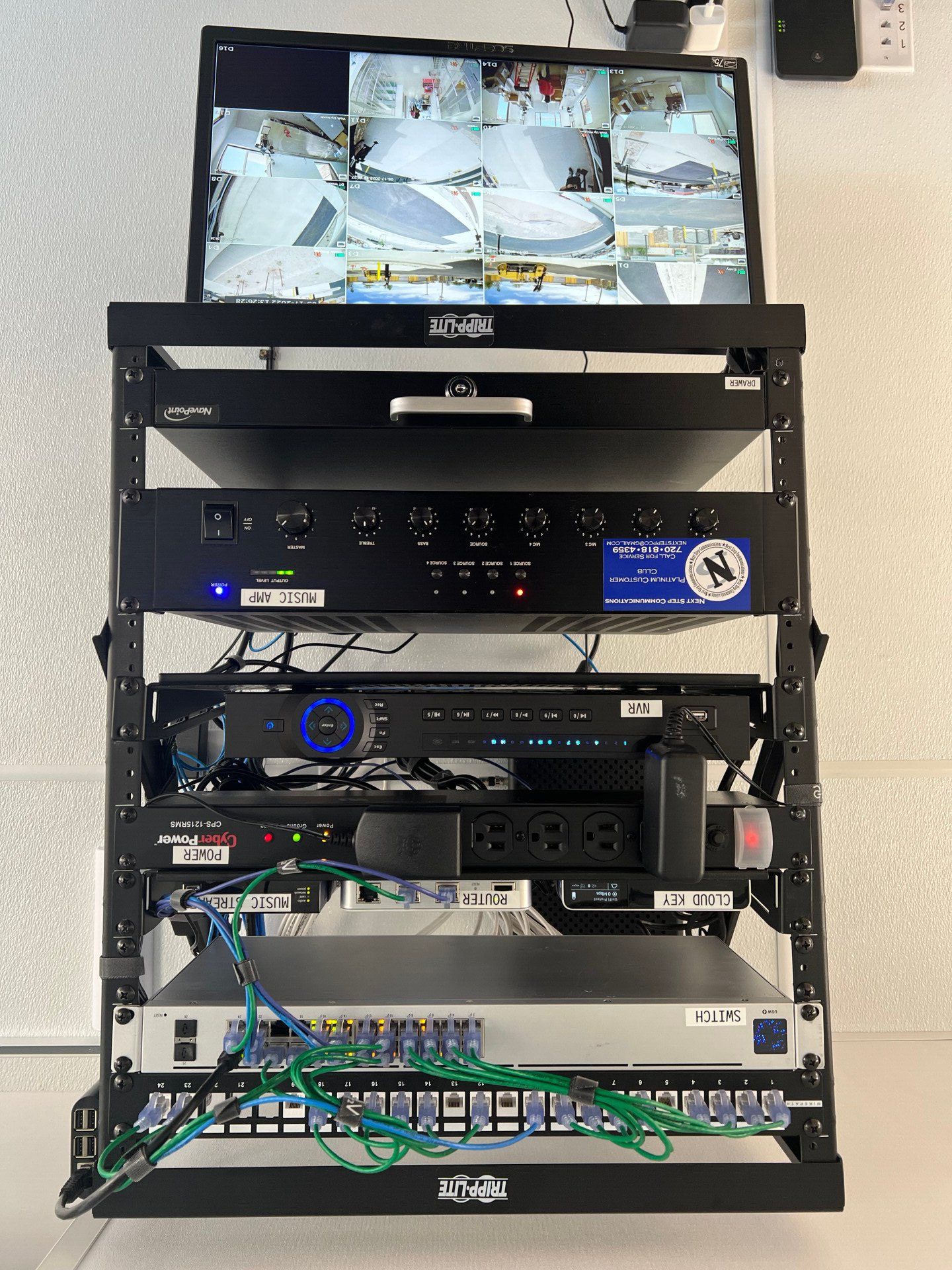 Rack-mounted AV/control equipment with a monitor displaying multiple camera feeds.