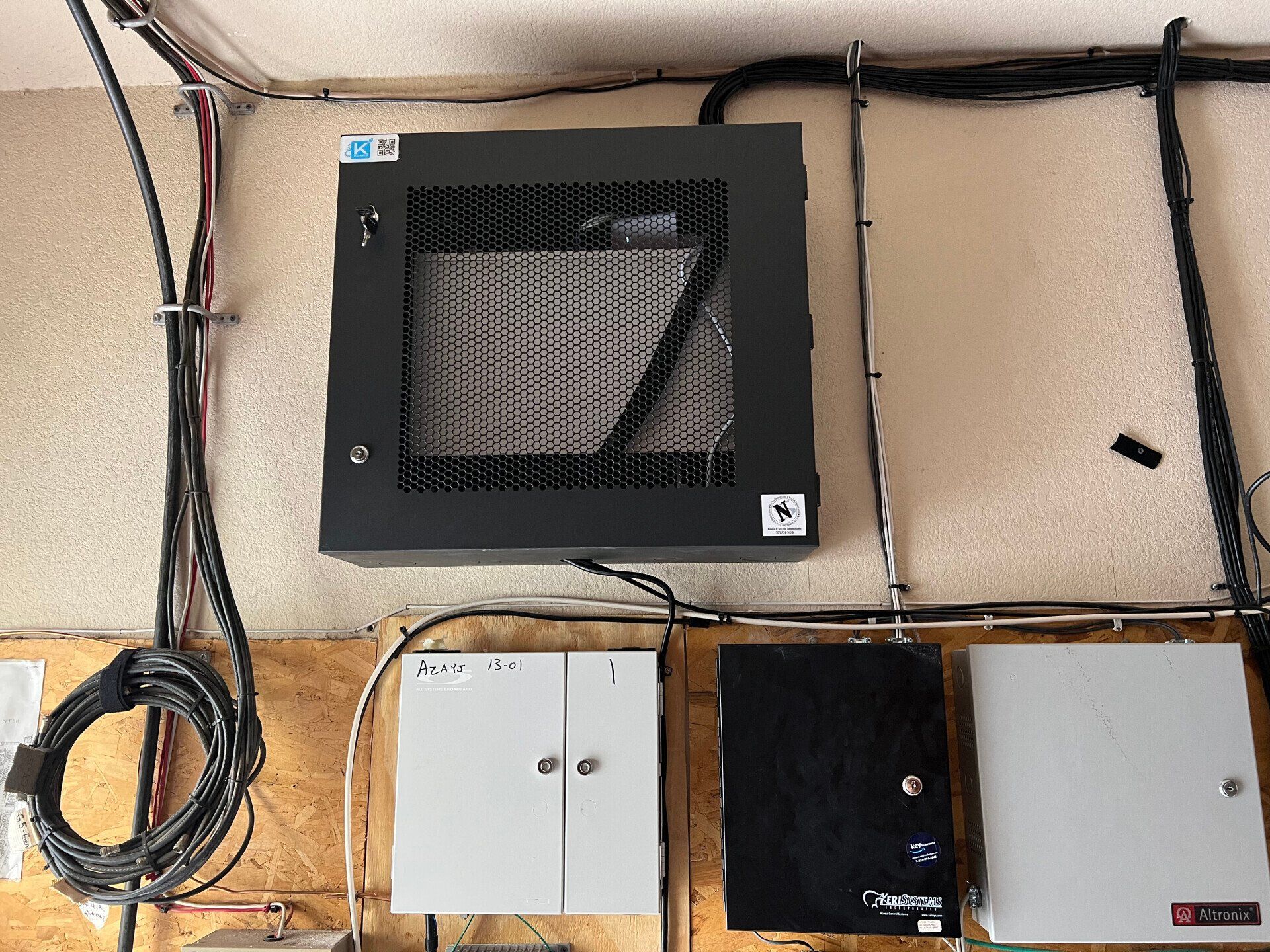 Wall-mounted electrical control boxes and cables on a beige utility wall