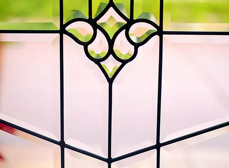Decorative stained-glass window with black lead lines and pale pink and green panes