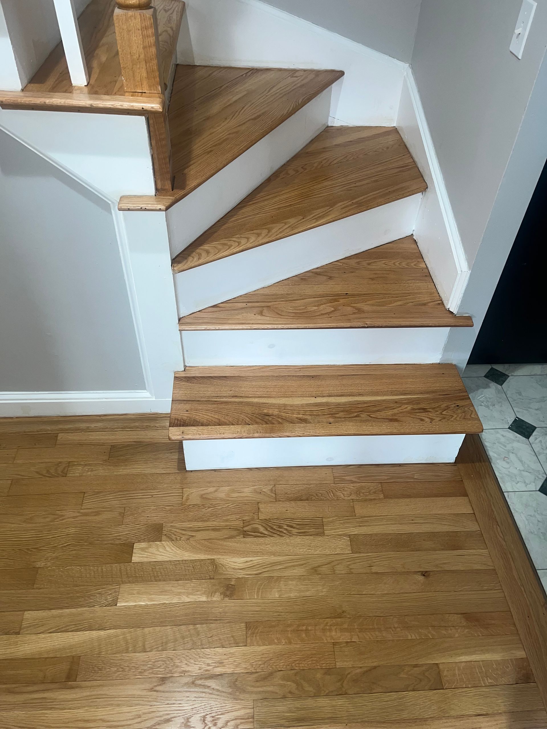 Freshly installed, gleaming hardwood floor in a well-lit room.