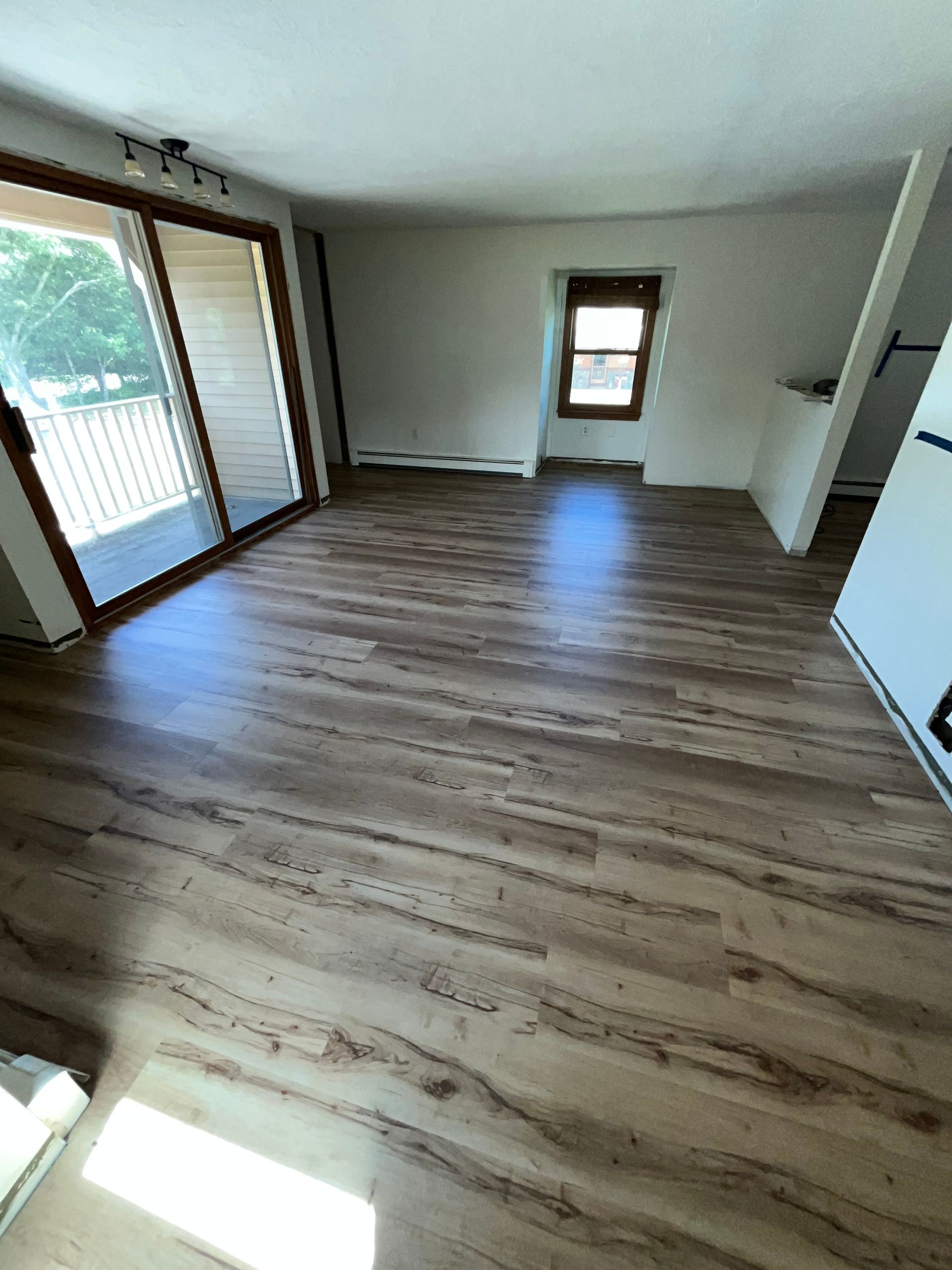White couch positioned near a black mat on a hardwood floor.