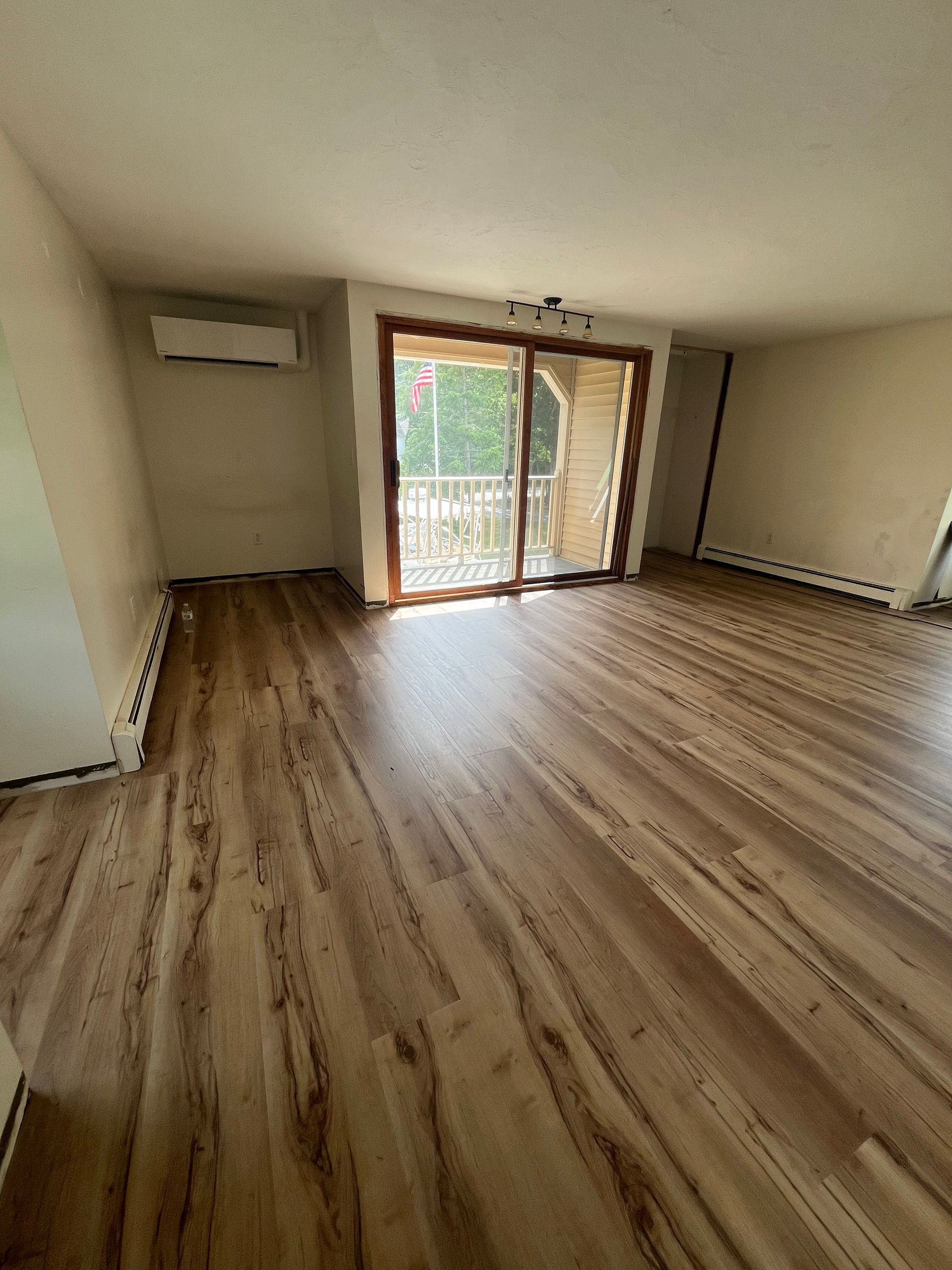 Freshly installed, gleaming hardwood floor in a well-lit room.