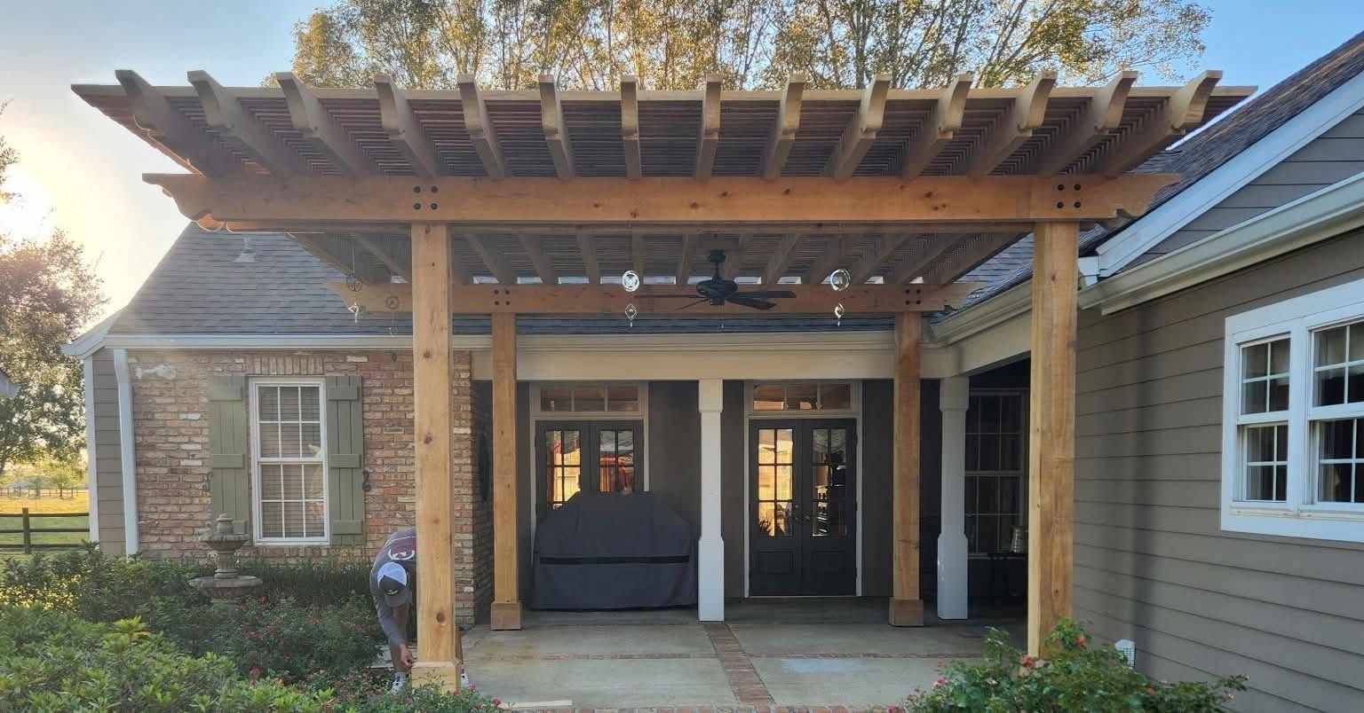 Wooden front porch with pergola roof and hanging lights on a gray house at sunset