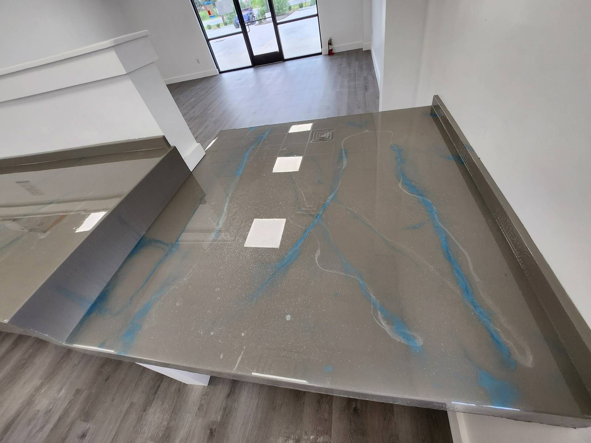 Blue-taped cardboard ramp in a building entryway, leading down to glass doors.