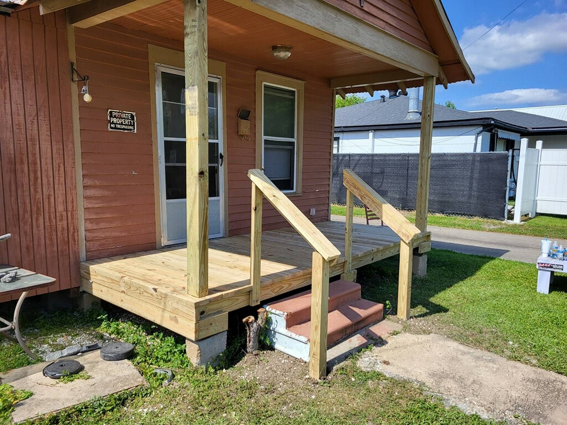 Wooden porch with ramp and handrails on a small house exterior