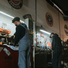 Mechanic working at a dimly lit repair station with tools and equipment in a garage-like workshop