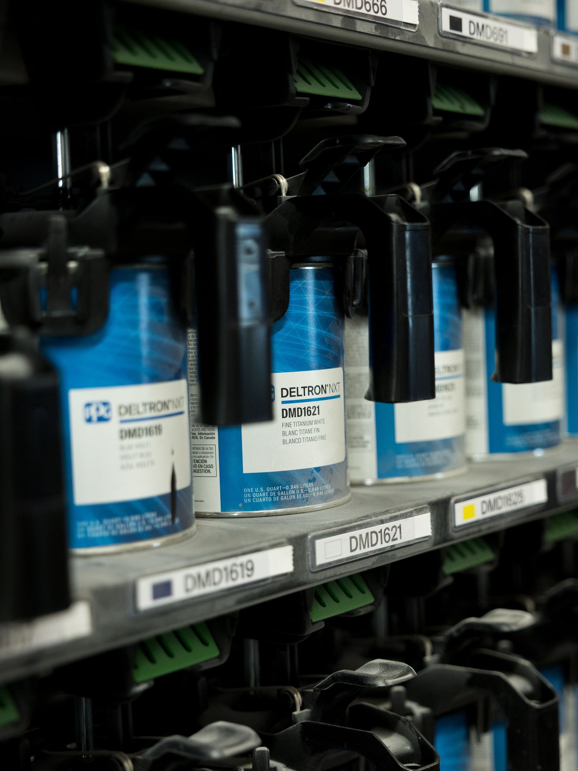 Rows of blue and white industrial spray cans on a store shelf