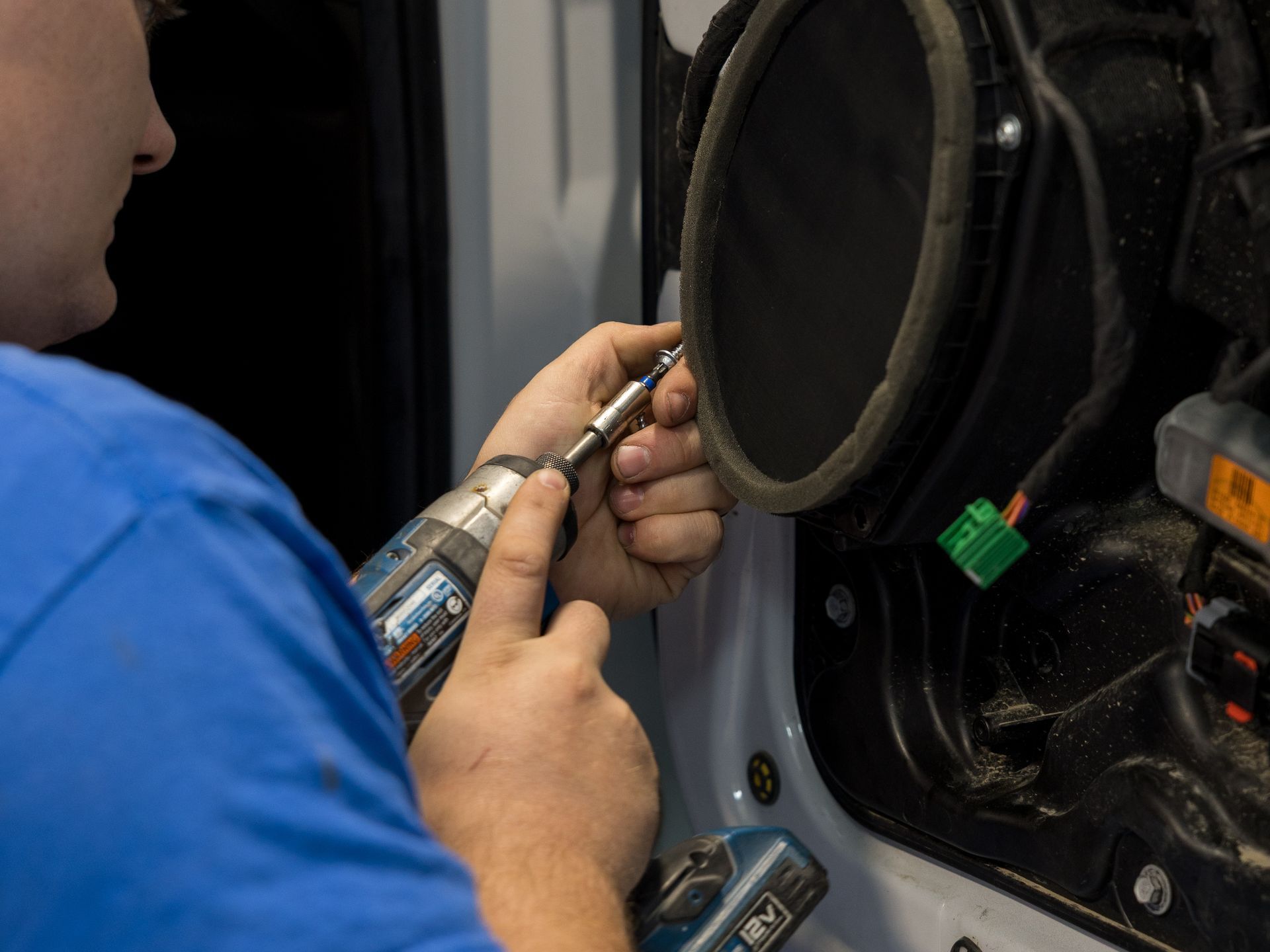 Mechanic using a tool to work on the inside of a vehicle wheel assembly