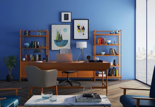 Stylish blue home office with wooden desk, art on the wall, shelves, and a city view through large windows