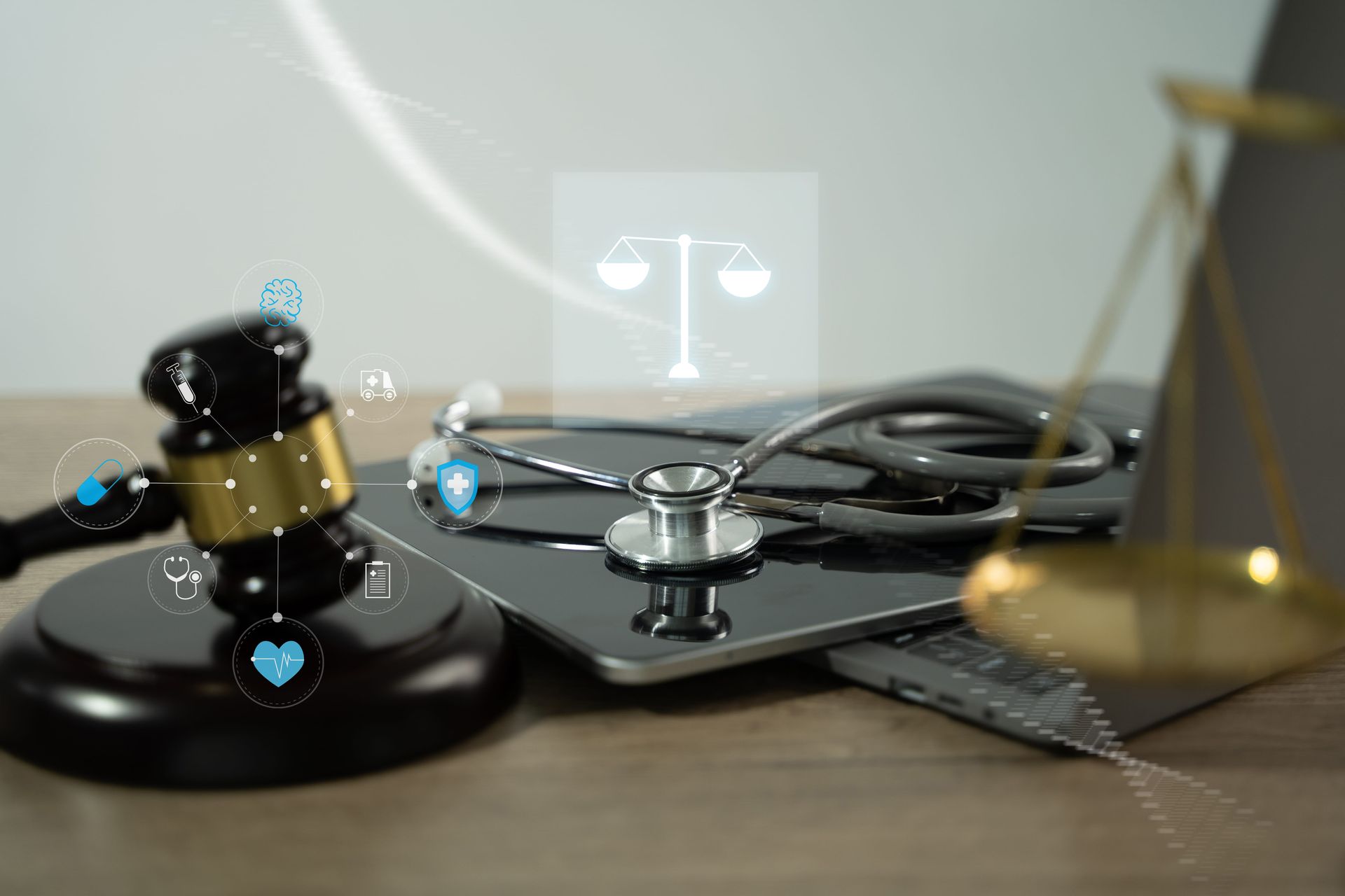 Lawyer's desk with gavel, stethoscope, and justice scales on a laptop keyboard