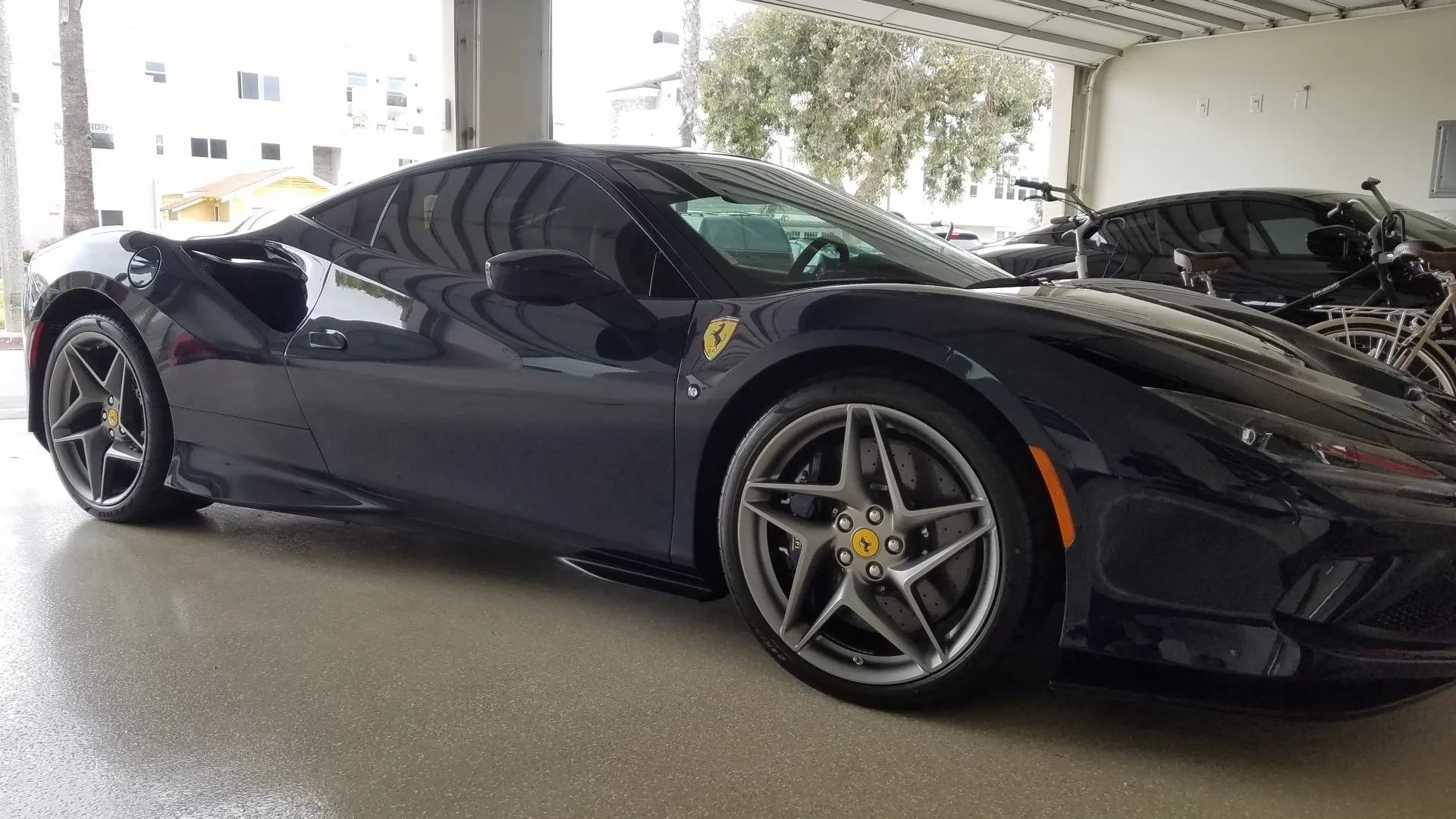 Blue Ferrari sports car parked inside a garage.