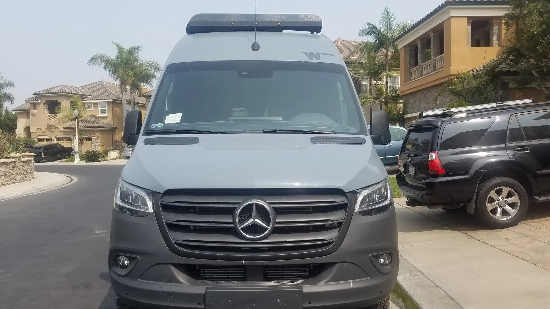 Gray Mercedes camper van parked on a residential street.
