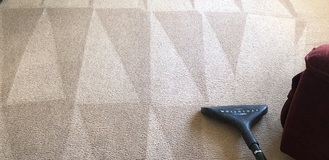 Carpeted floor with a blue vacuum head at the lower right corner.
