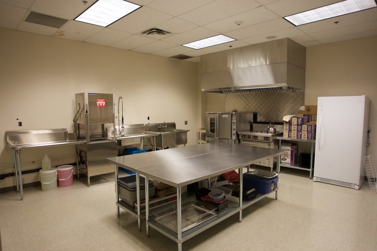 A kitchen with stainless steel appliances and a large table