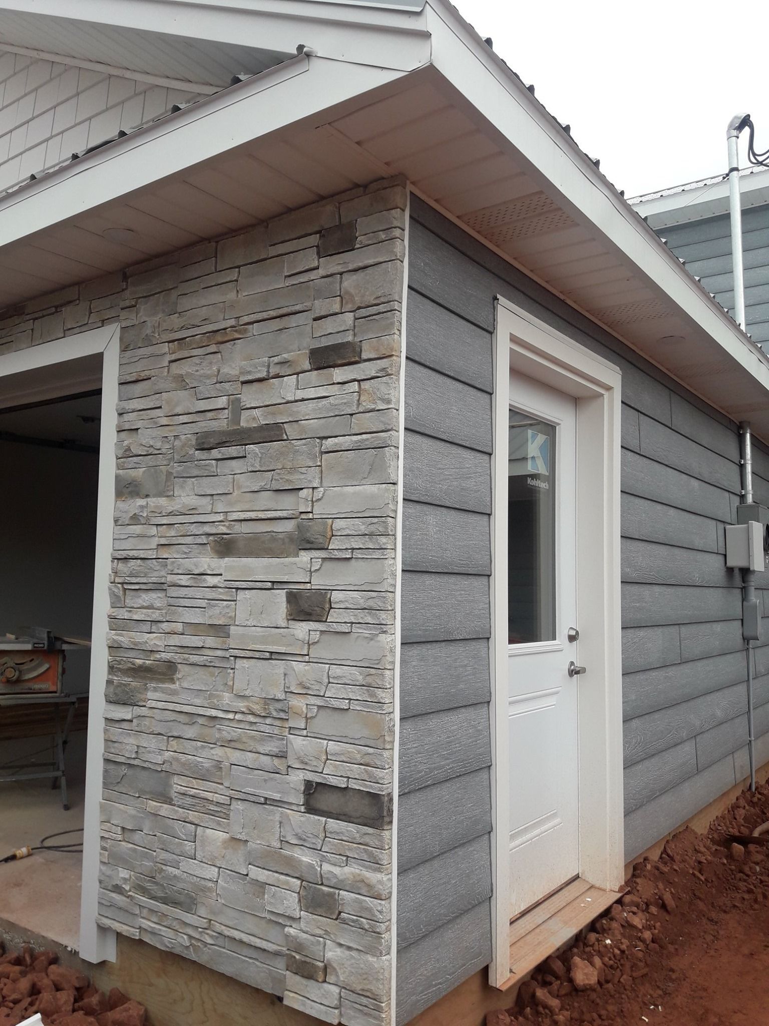 A house with a stone siding and a white door