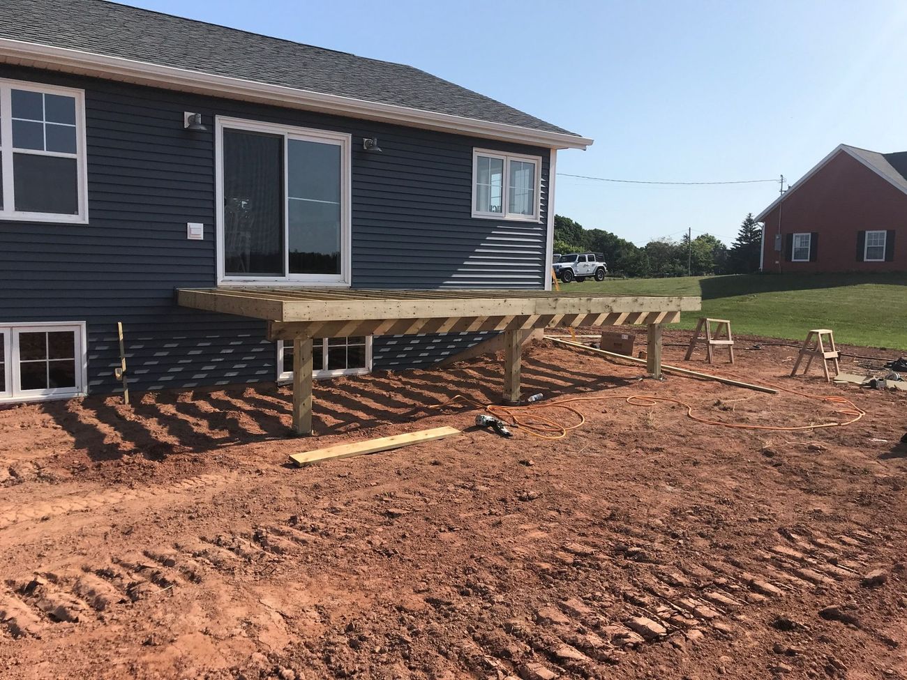 A wooden deck is being built in front of a house.
