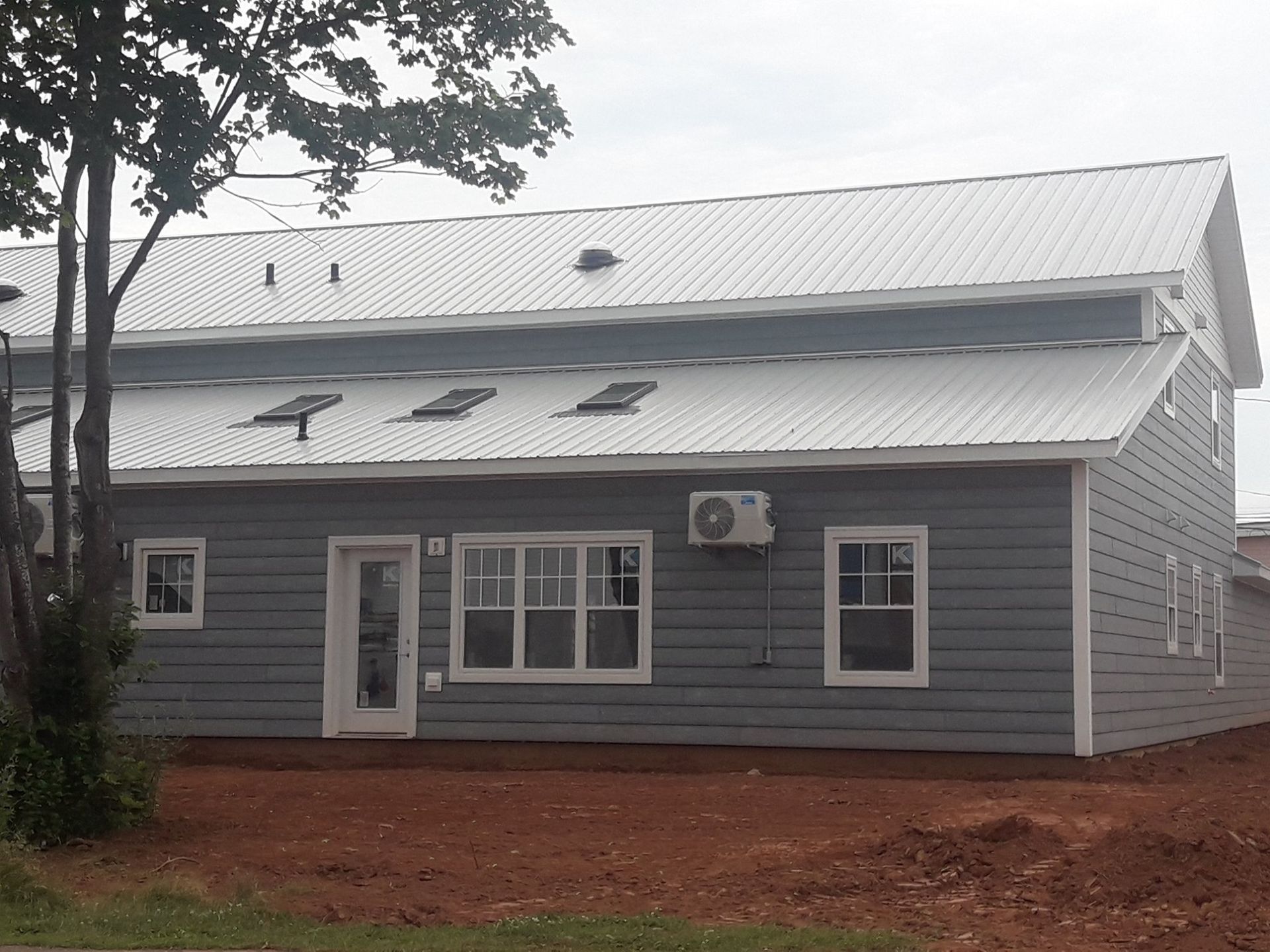 A gray house with a white roof and white windows