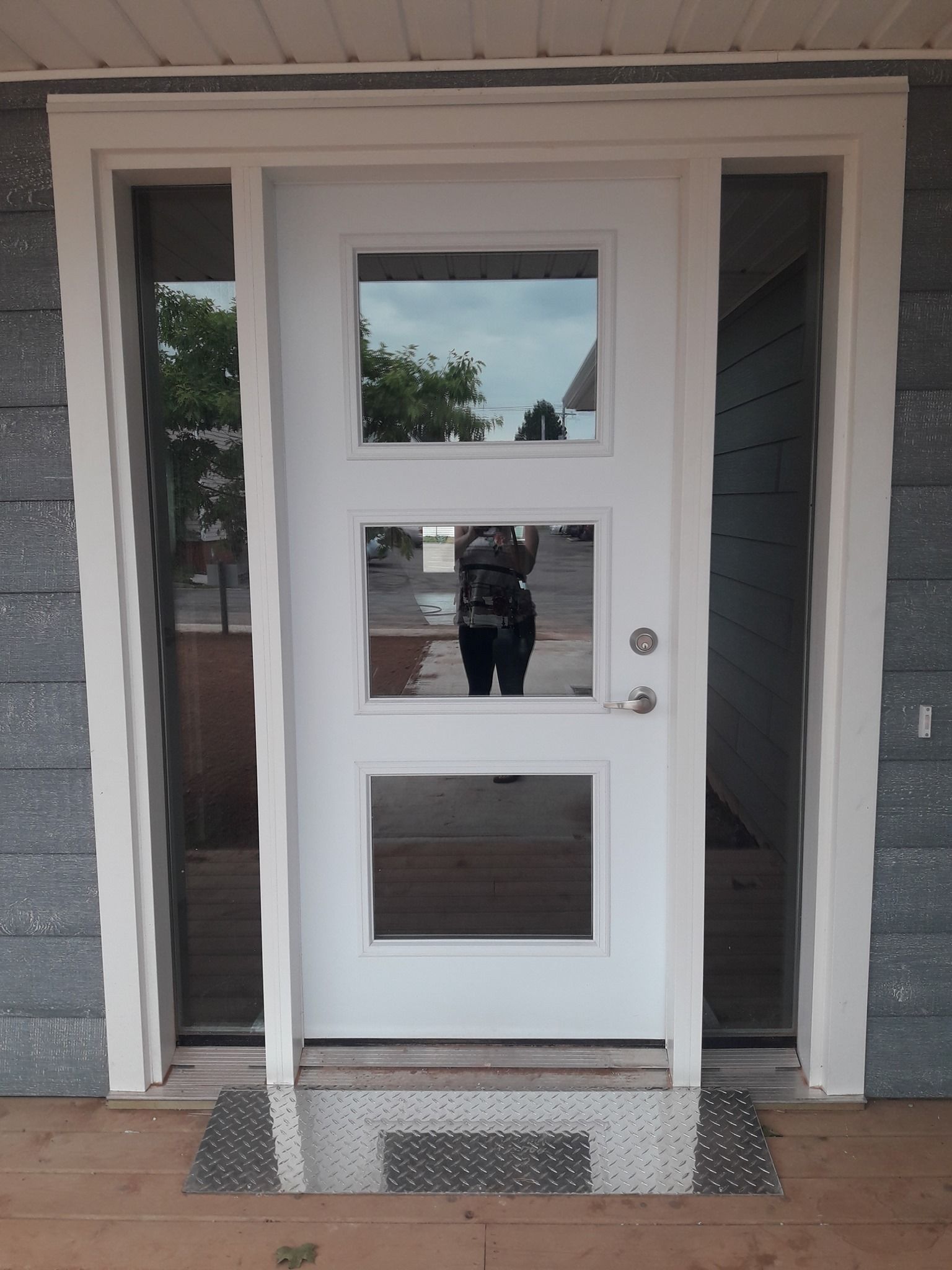 A white door with a reflection of a person in it
