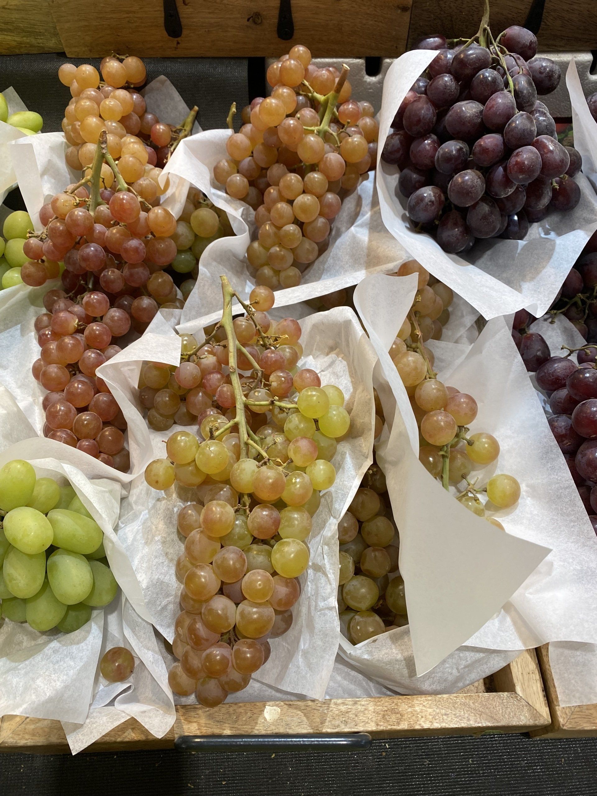 A bunch of different types of grapes wrapped in paper