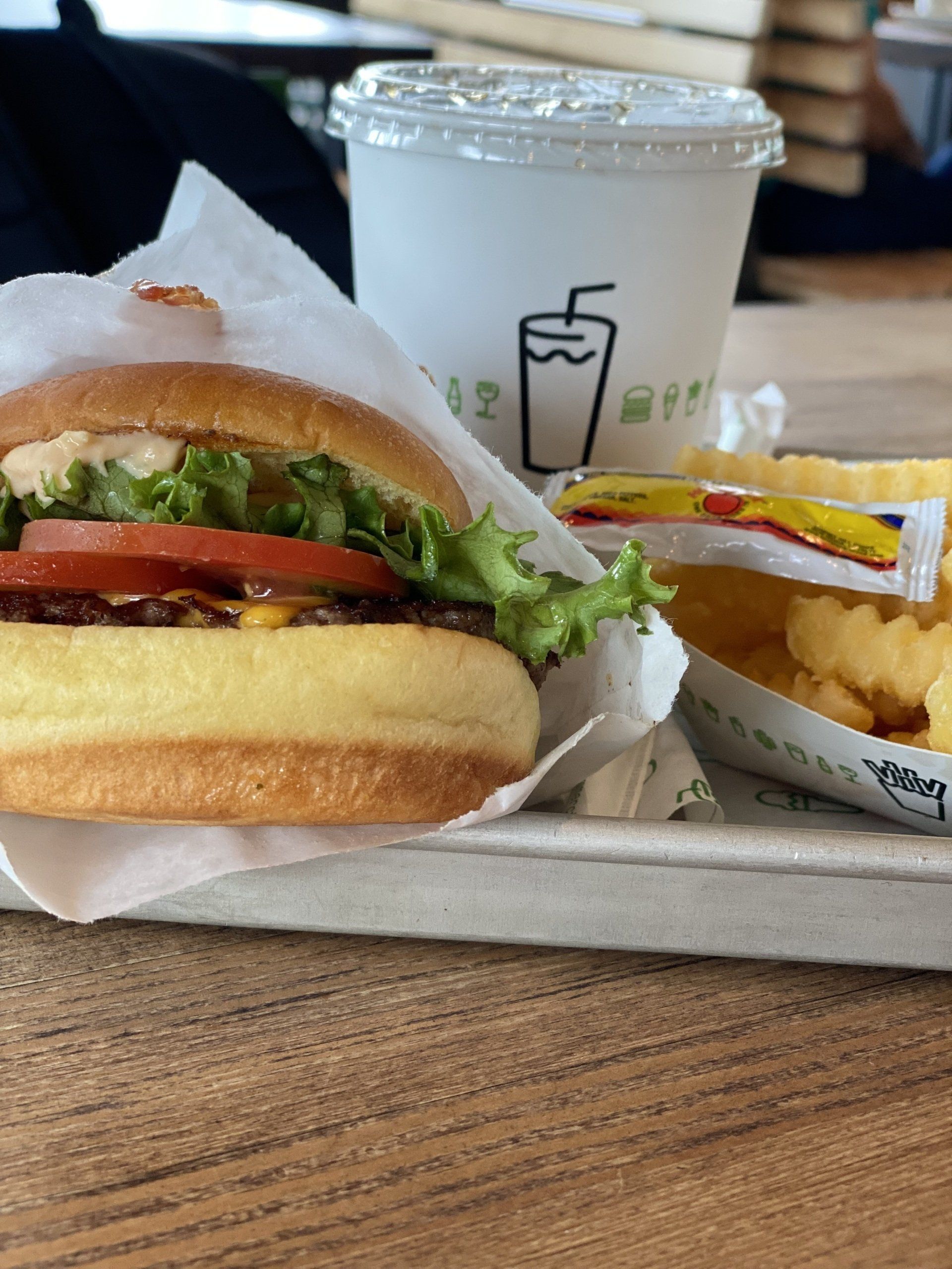 A hamburger and french fries are on a tray on a table.