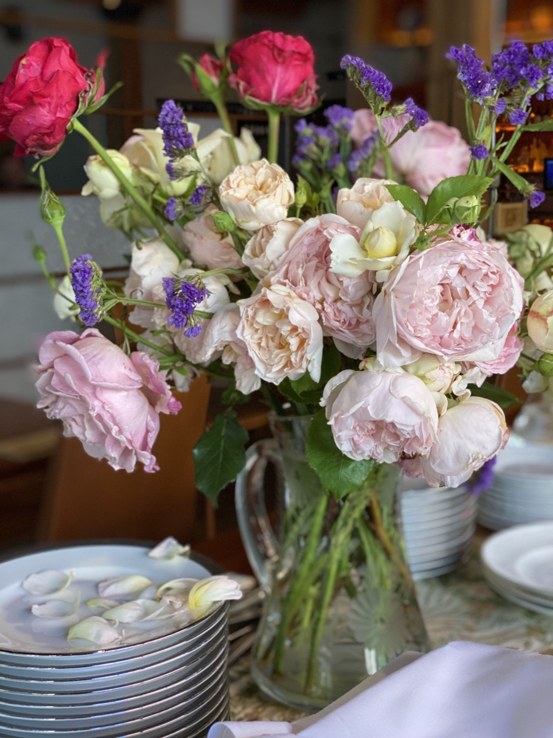 A vase filled with pink and purple flowers is sitting on a table.