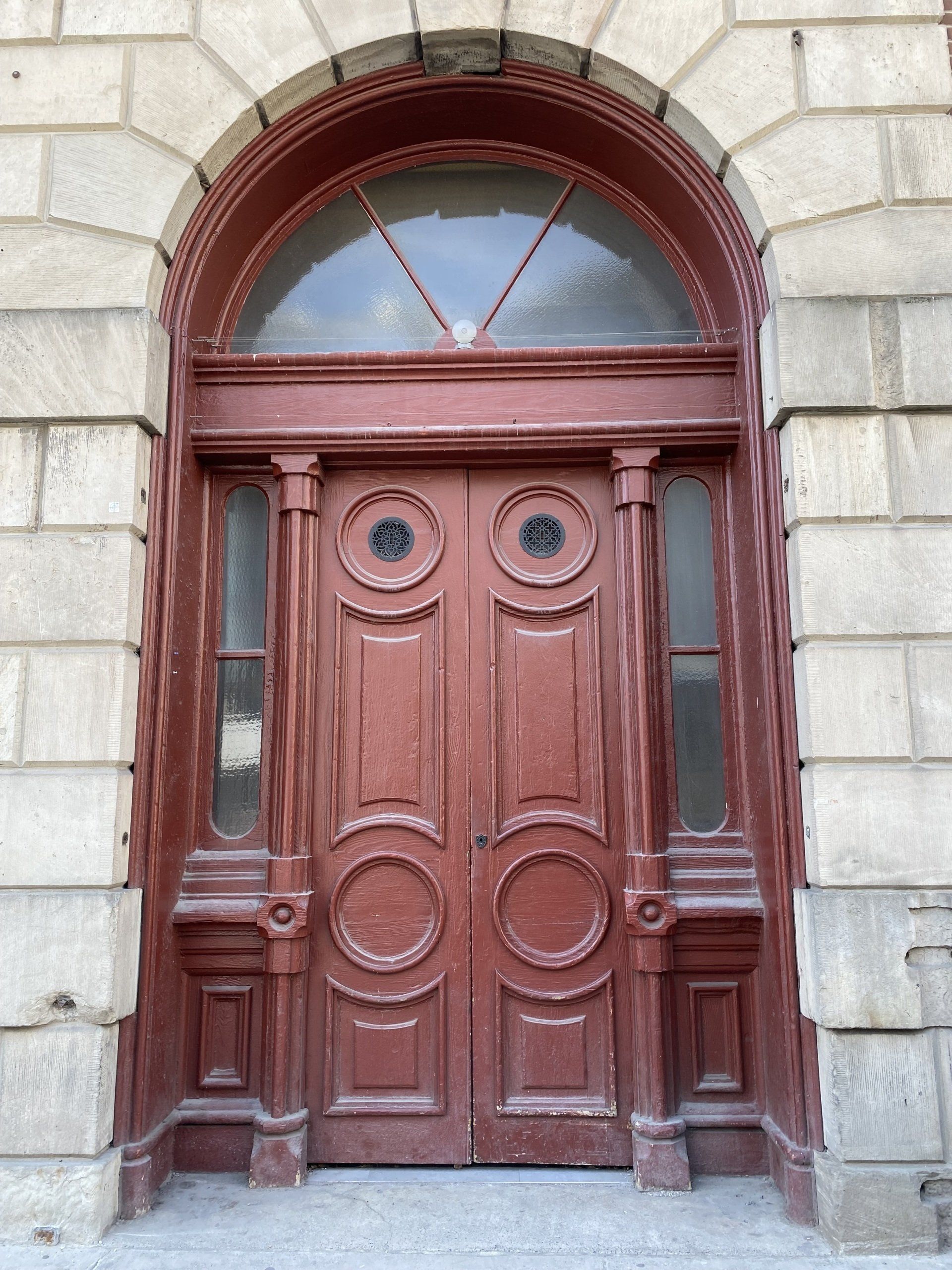A brick building with a red wooden door