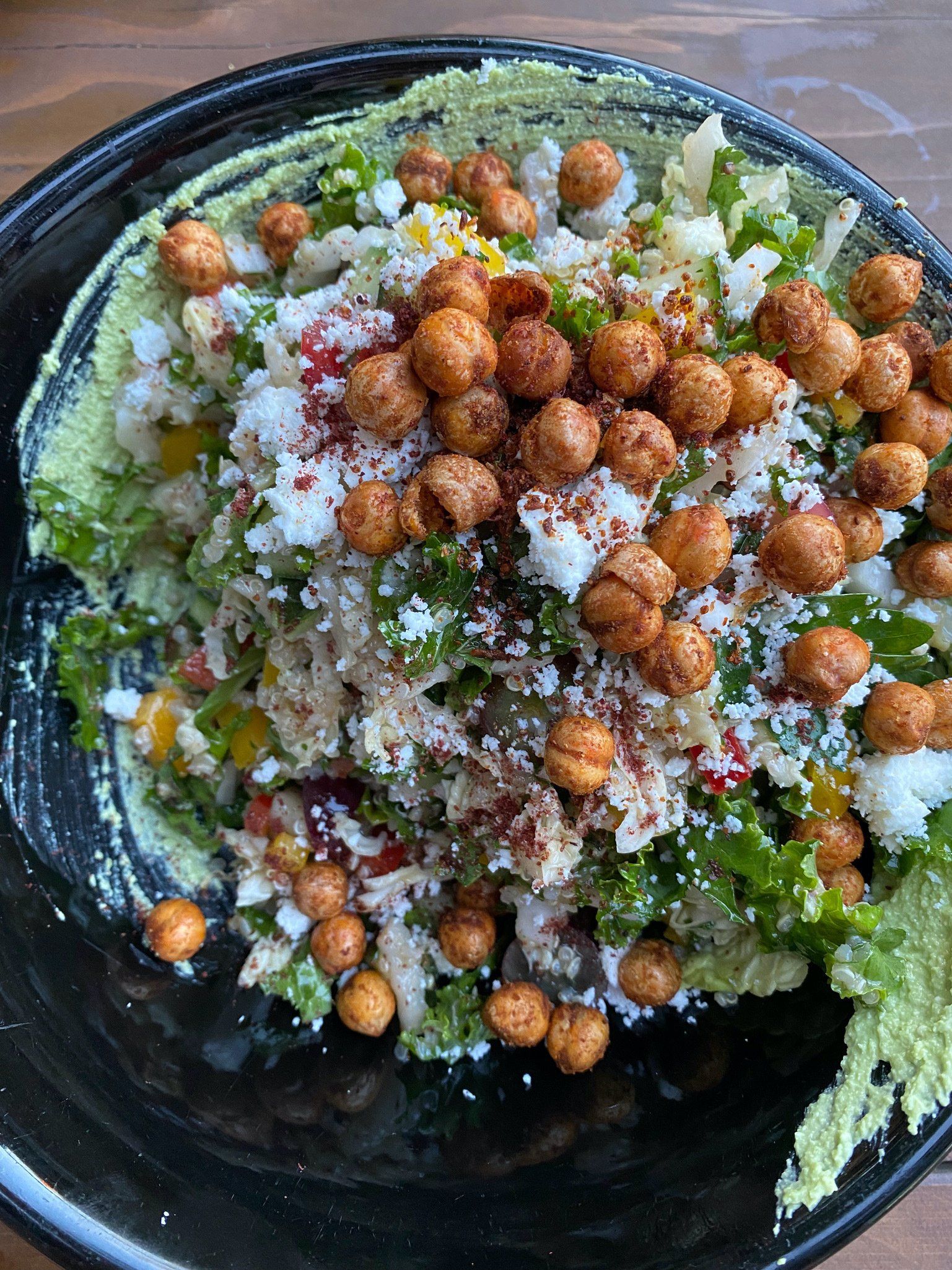 A close up of a plate of food with chickpeas on a table.