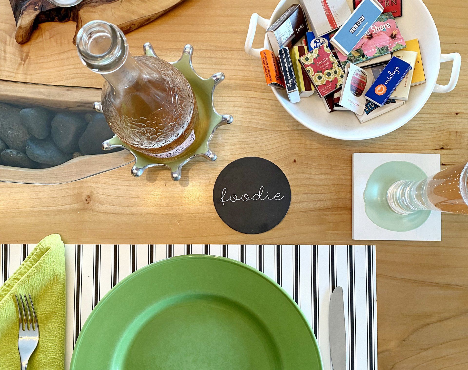A table setting with a green plate and a bowl of candy