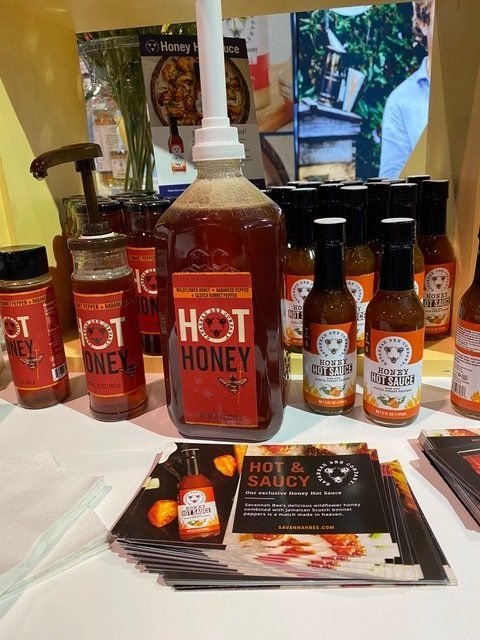 Several bottles of hot honey are on a table