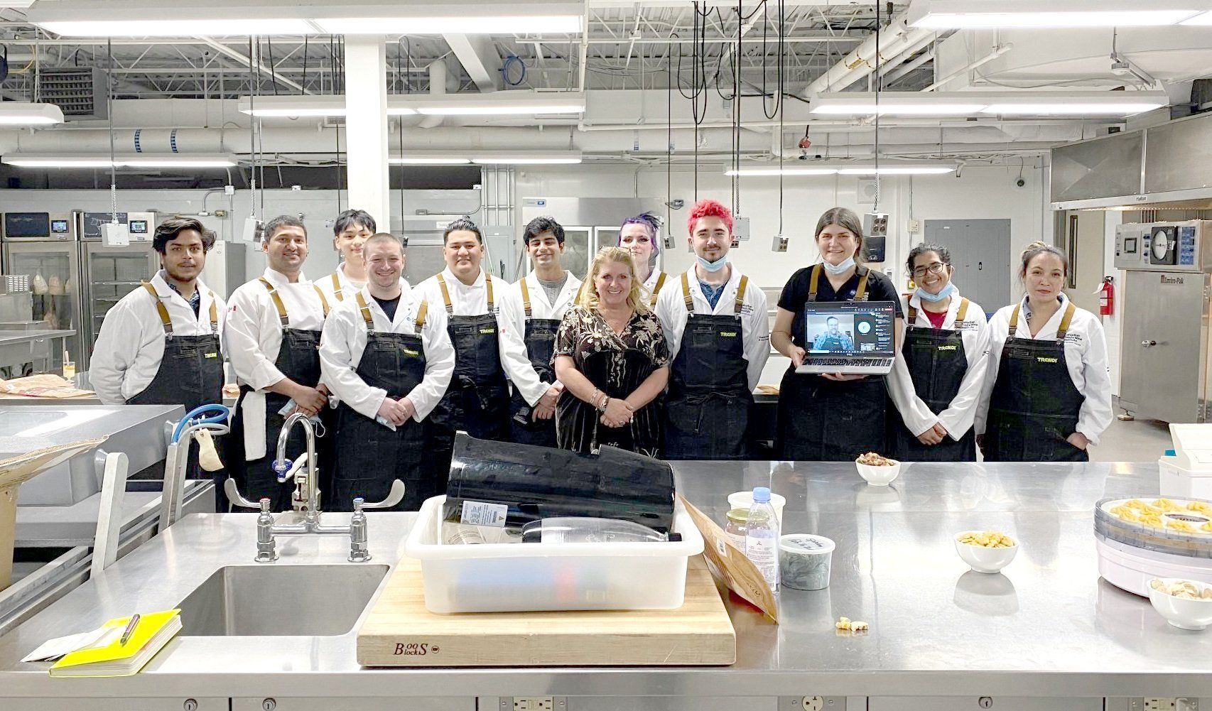 A group of people are posing for a picture in a kitchen.