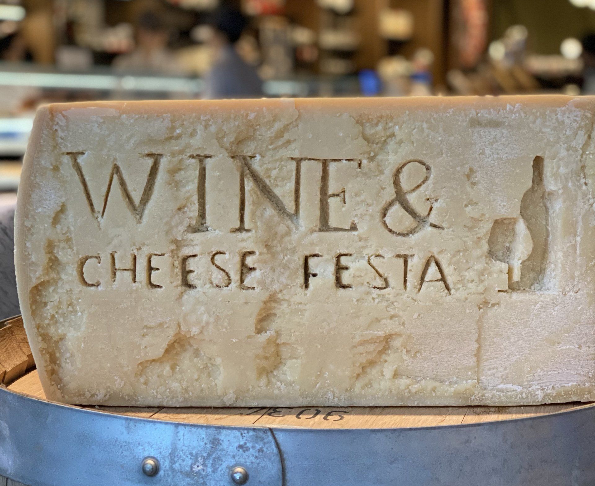 A piece of cheese that says wine and cheese festa on it
