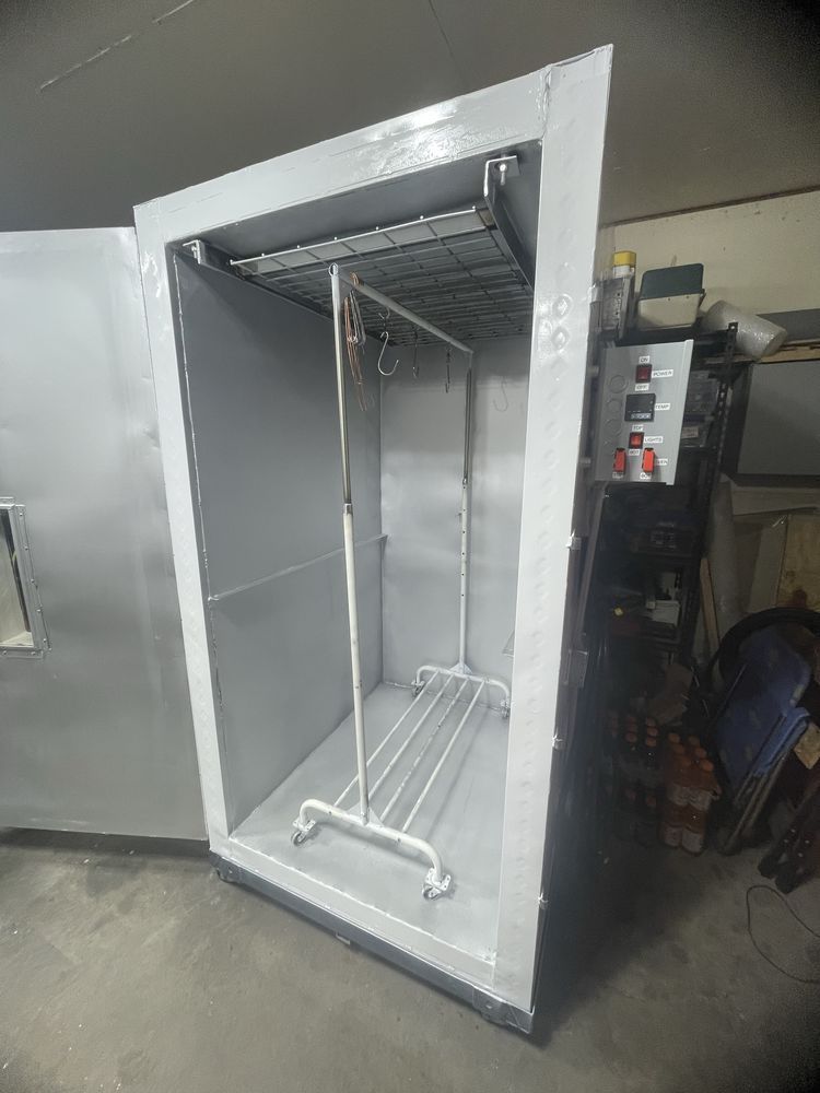 A tall, white rectangular drying or curing cabinet with a metal interior rack and a control panel on the side.
