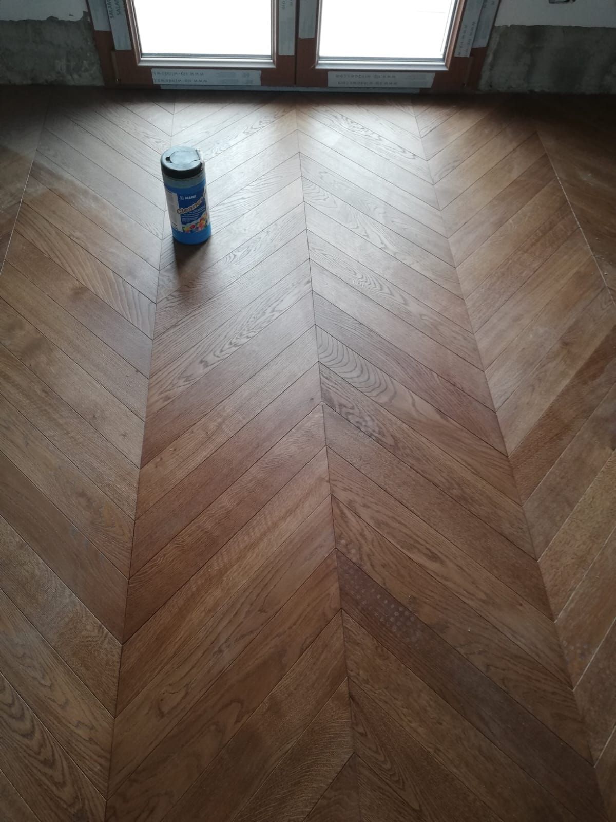 Pannello porta in legno con finitura marrone chiaro. Il pannello è caratterizzato da sezioni rettangolari di diverse dimensioni con venature del legno visibili.