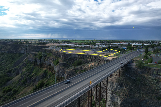 Bridge over deep canyon leading to a small town under cloudy skies