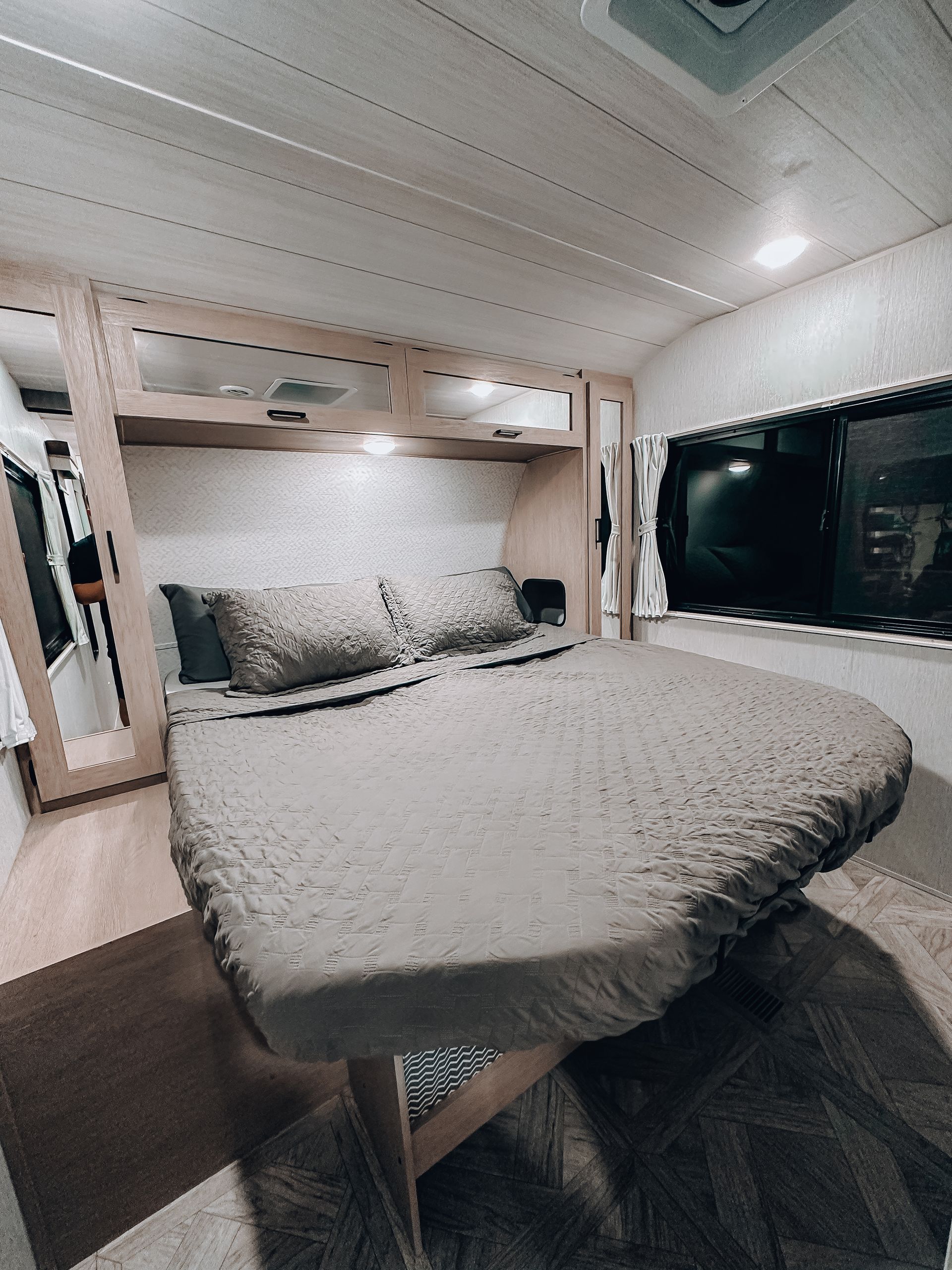 Small bedroom with a large bed, built-in shelves, and a window on the right.