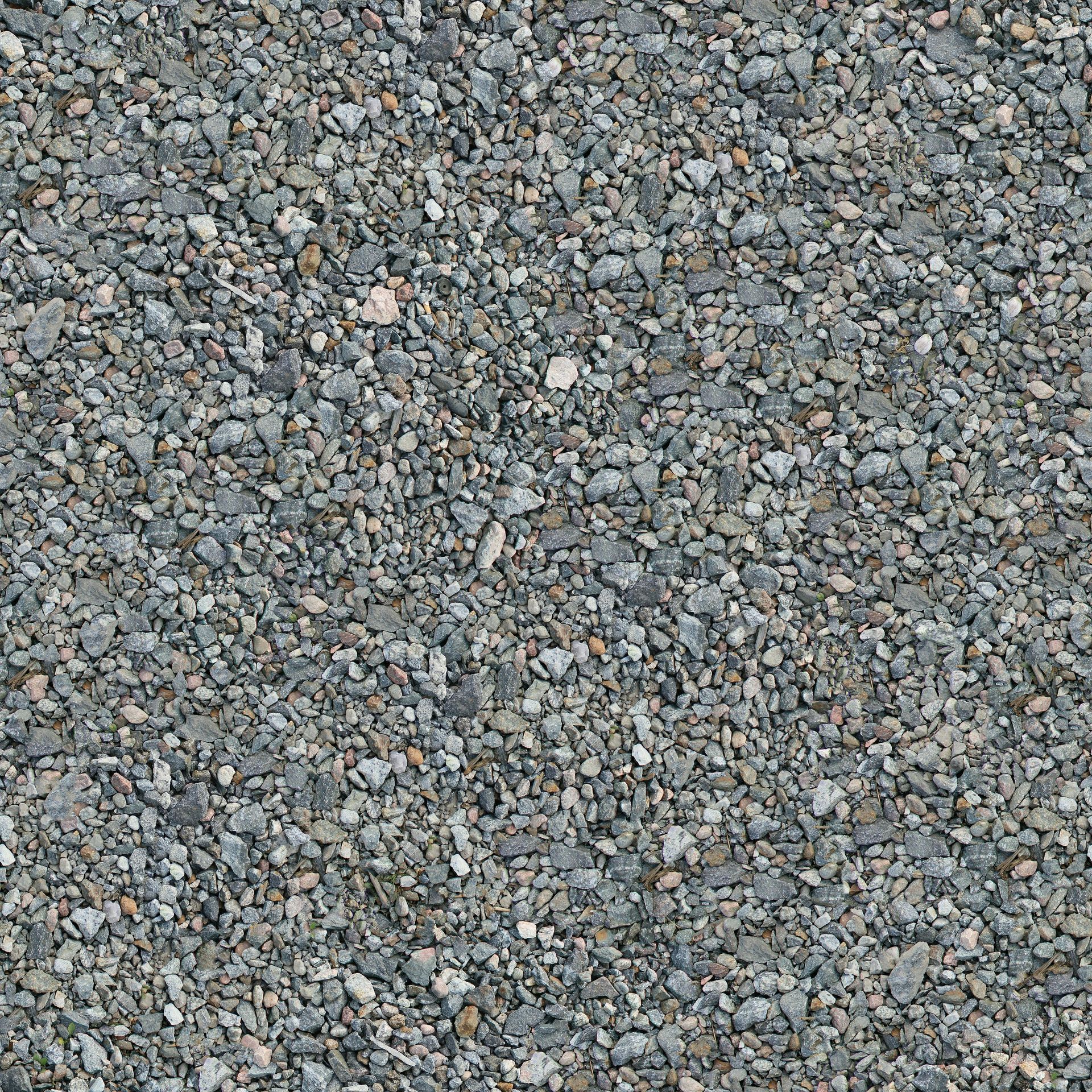 Close-up of gray gravel stones with scattered tan and brown pebbles.