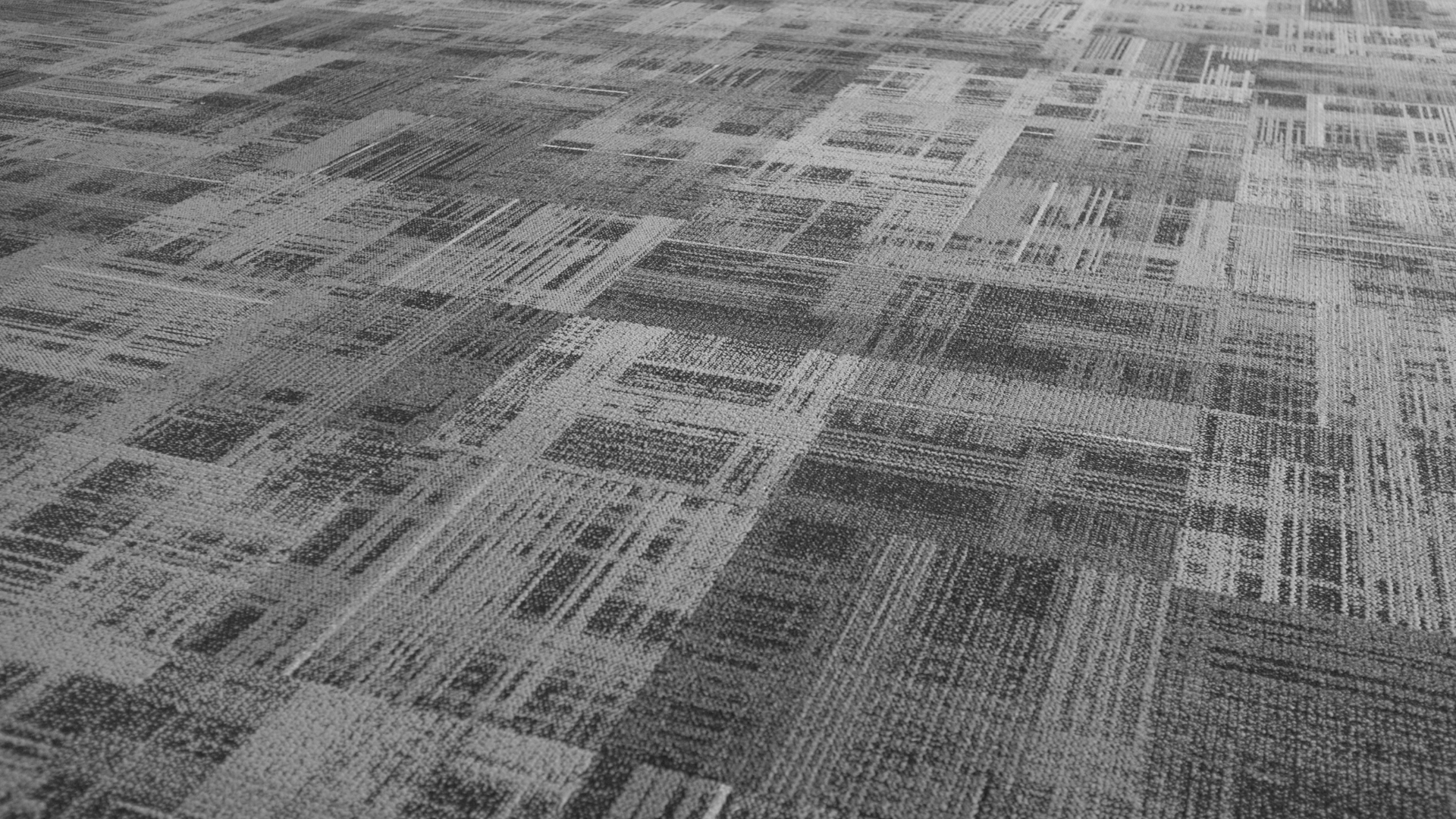 Textured, gray carpet with geometric patterns and varying shades.